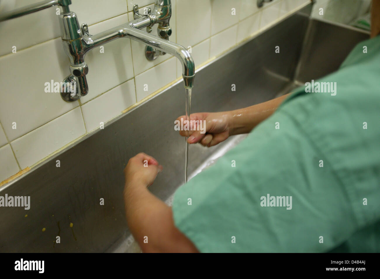 Surgeon washing hands with antibacterial soap prior to surgery. UK