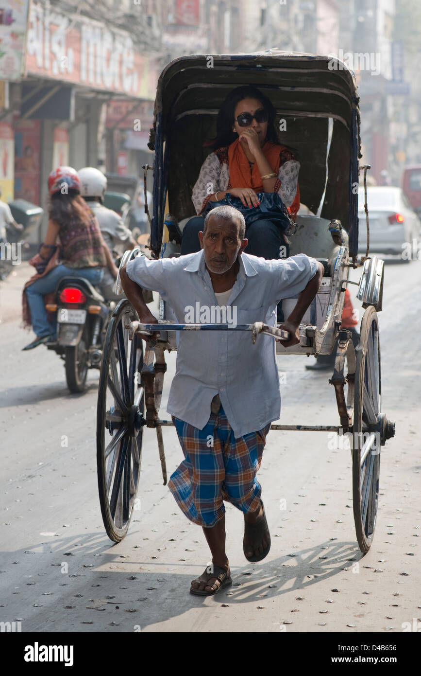 A rickshaw puller transports a woman In Kolkata, India Stock Photo Alamy