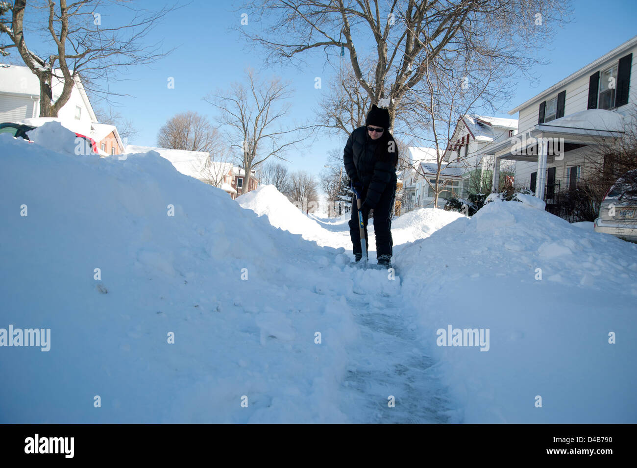 Woman shoveling snow after big snowfall, Kingston, Ontario, Canada Stock Photo