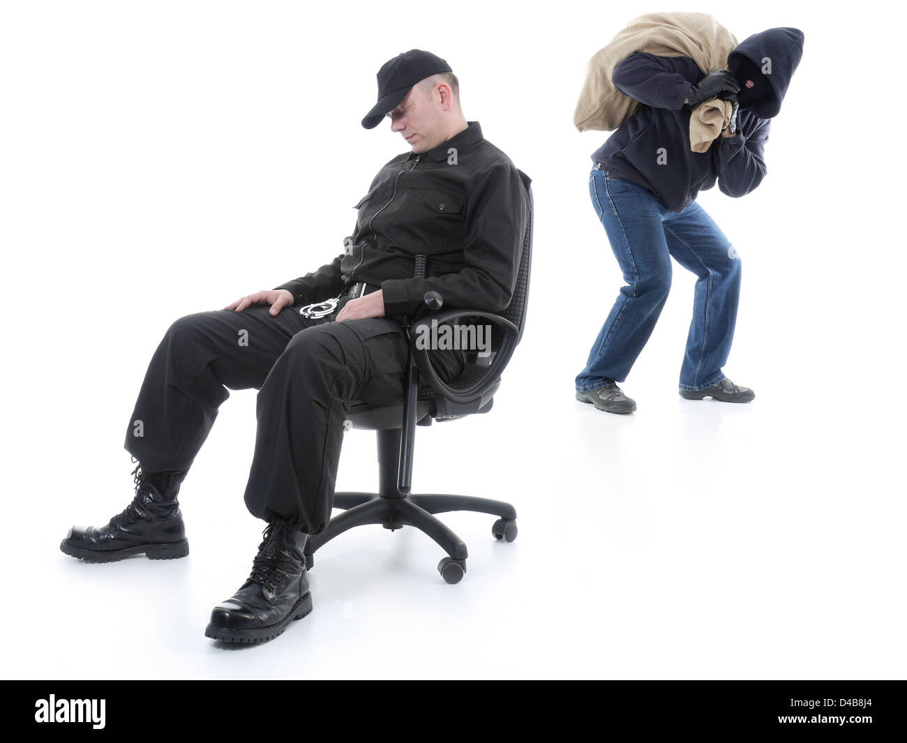 Security man sleeping on armchair being unaware of masked burglar stealing behind his back Stock Photo