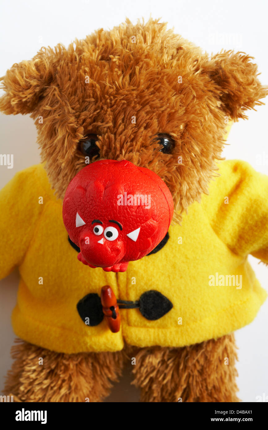 Teddy bear wearing red nose for Comic Relief for Red Nose Day set against white background Stock Photo