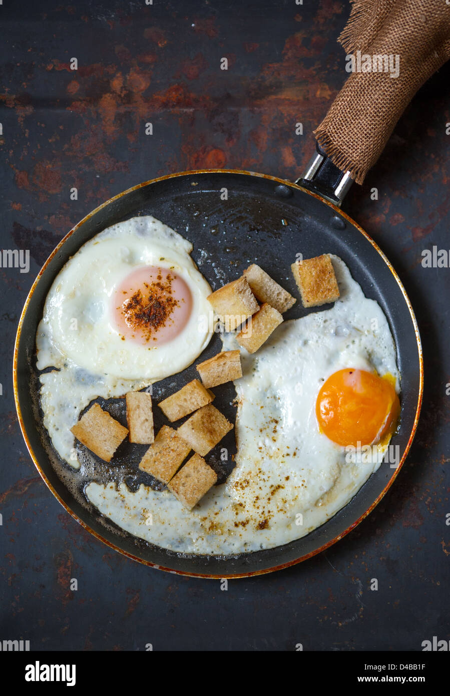 Frying pan full of scramble eggs from two eggs with a small pieces of