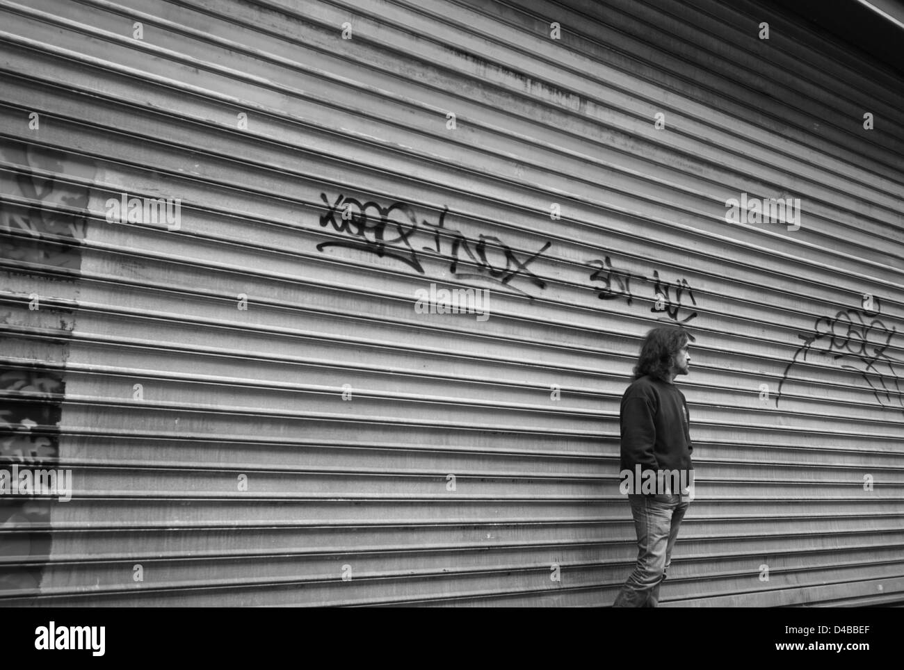 Man standing by security blinds, Rue Rambuteau / les Halles, Paris Stock Photo