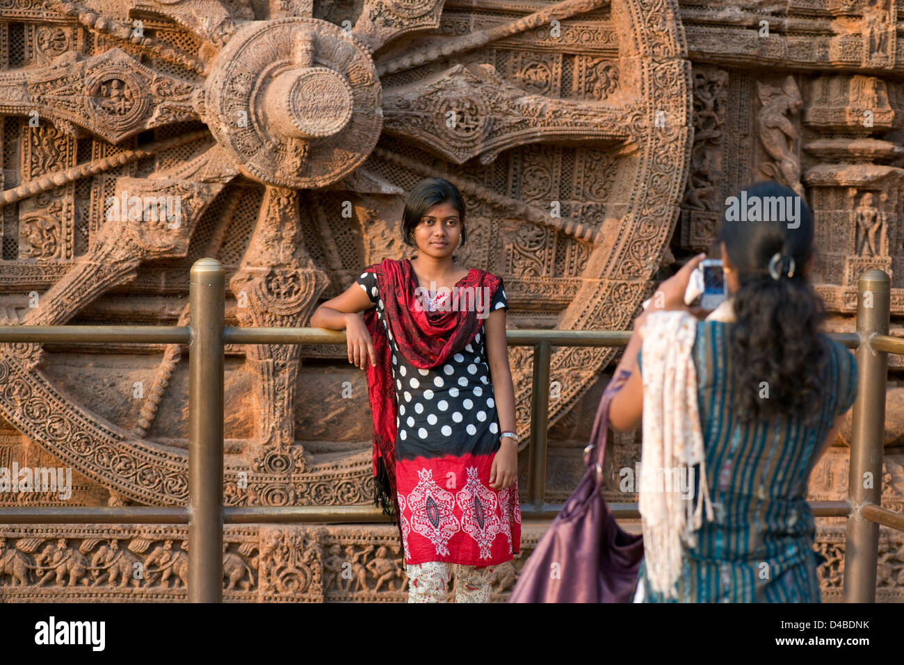 A woman takes a photograph of her friend at the Konark Sun Temple near Puri, Odisha state, India Stock Photo