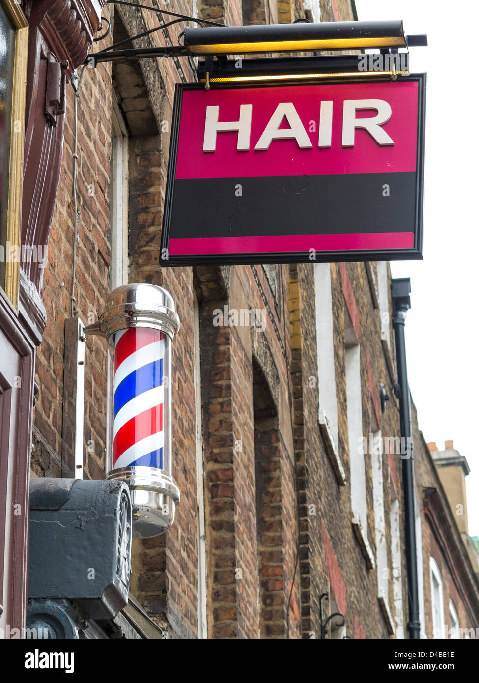 Barbers in London with Hair sign and barber's striped pole, London, England Stock Photo