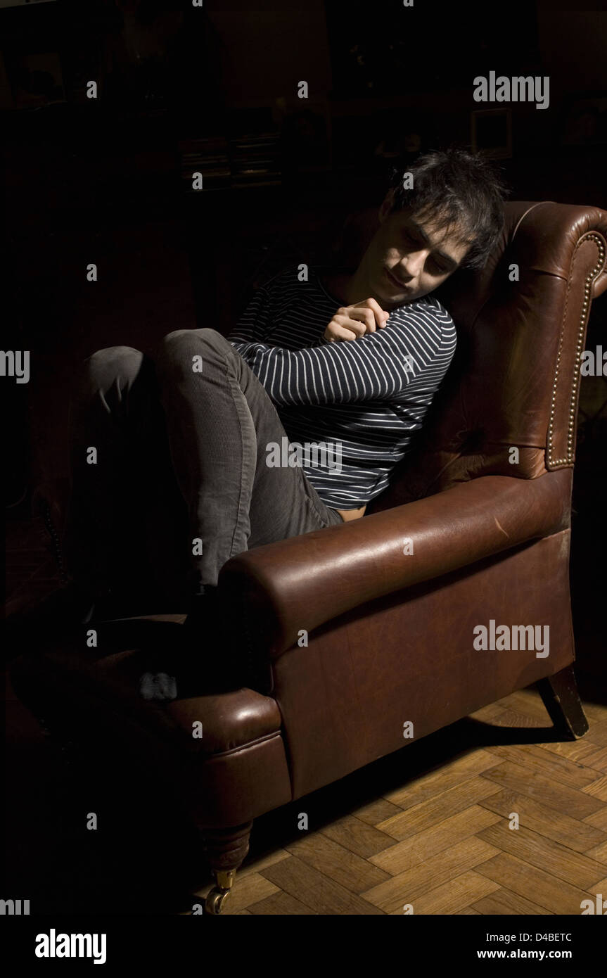 Man suffering from depression sitting in armchair Stock Photo