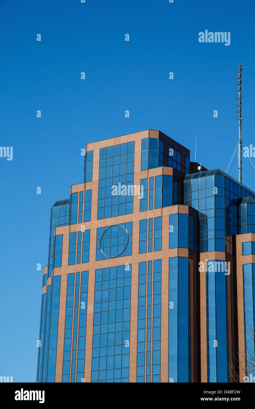 A modern glass and stone office building under clear blue skies Stock Photo