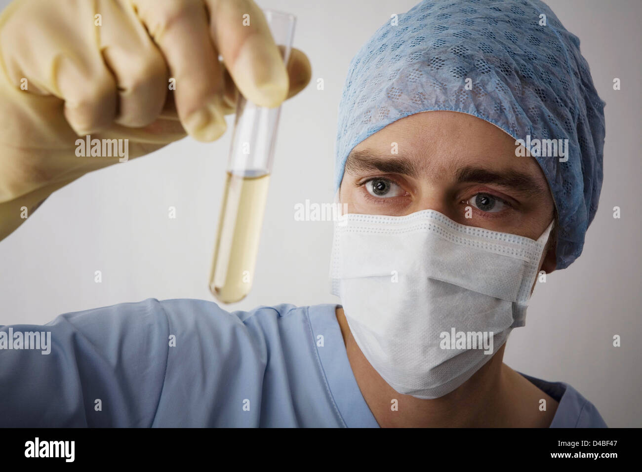 Laboratory technician examining liquid contents of test tube Stock Photo