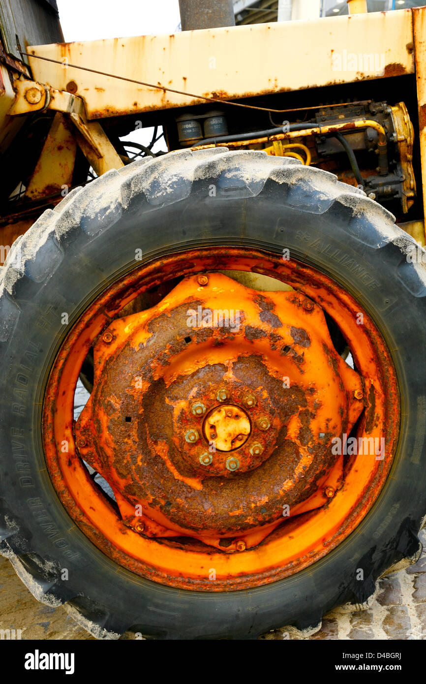 Orange and rusting painted tractor wheel. Stock Photo