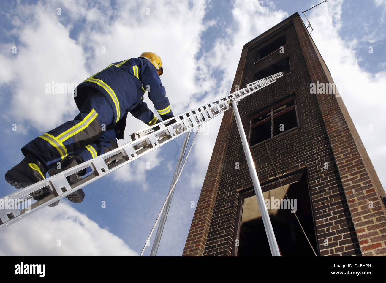 A fire fighter Hertfordshire Fire & Rescue Service UK scaling ladder