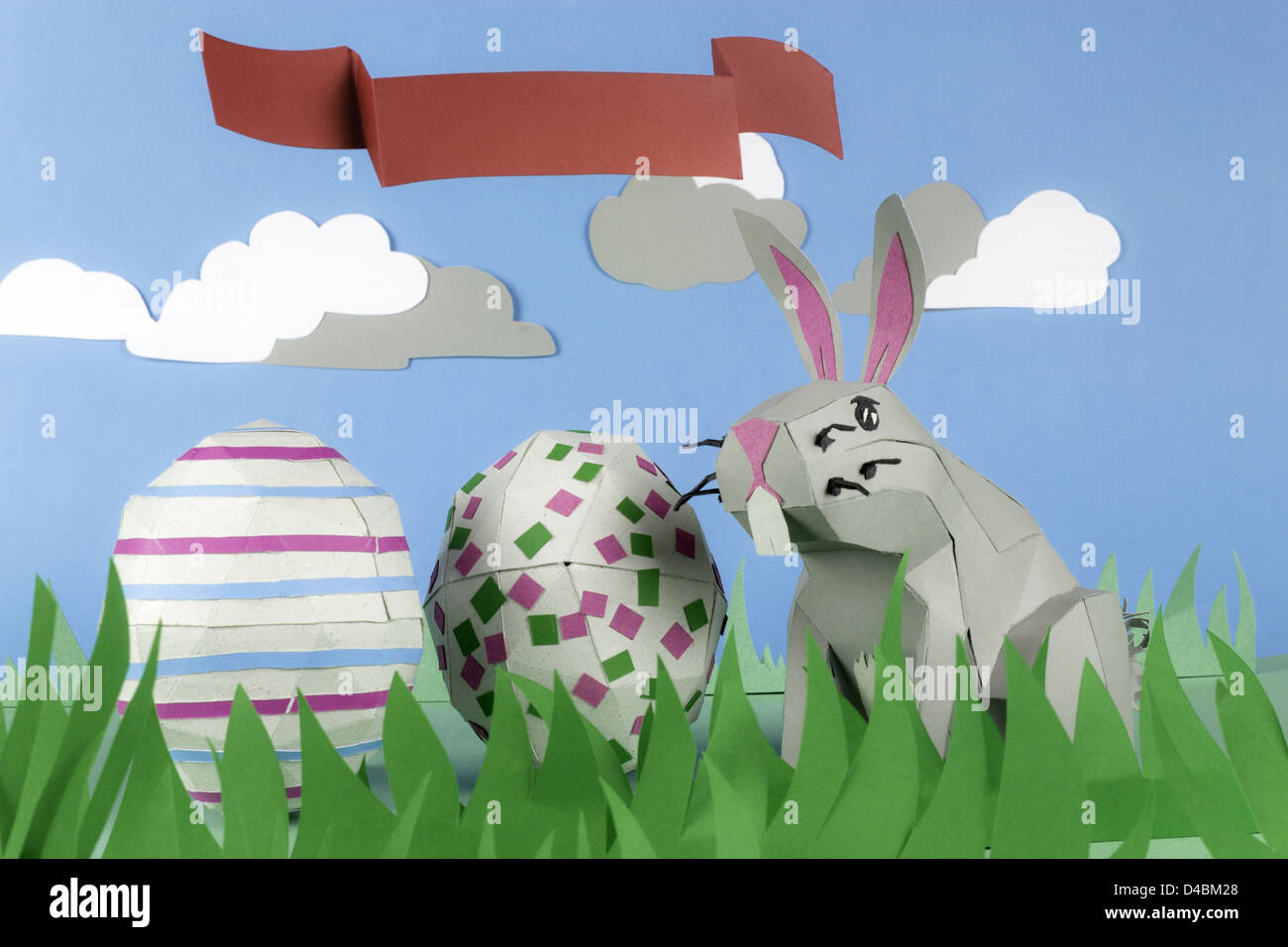Rabbit and eggs made of paper in a happy paper environment and a ribbon ...