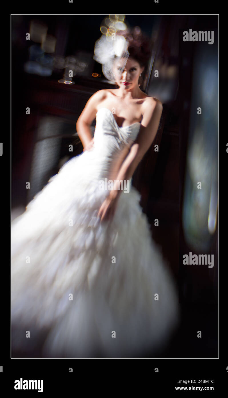 A white European female, woman age 25-30 wearing an elegant wedding dress. The image has a lot of movement and blur in color. Stock Photo