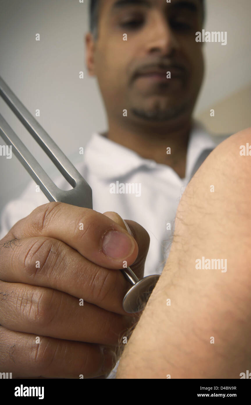 Doctor assessing patients sensation to vibration using tuning fork Stock Photo - Alamy Doctor assessing patients sensation to vibration using tuning fork Stock Photo - Alamy