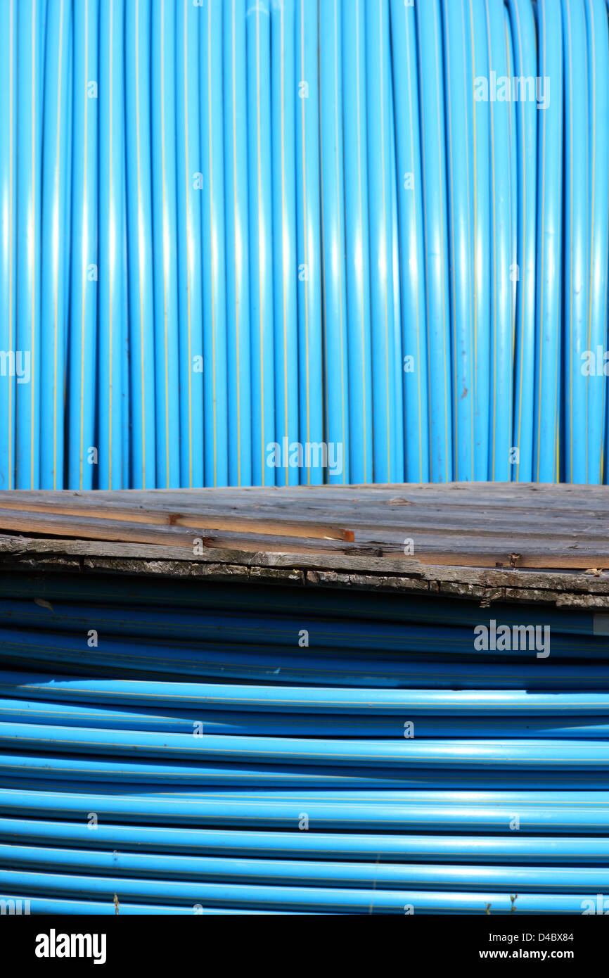 blue pvc long tube on wooden spool Stock Photo