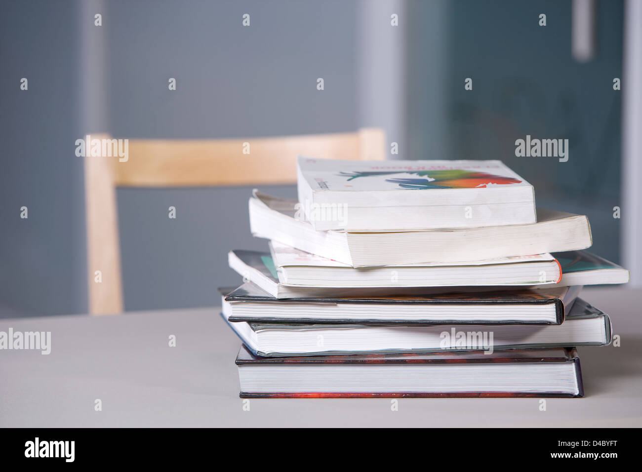 Stack of textbooks on a desk in a modern classroom Stock Photo