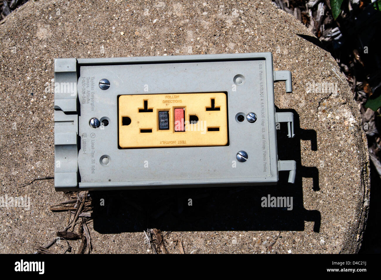 Ground fault GFCI electric receptacle sitting on a cement platform
