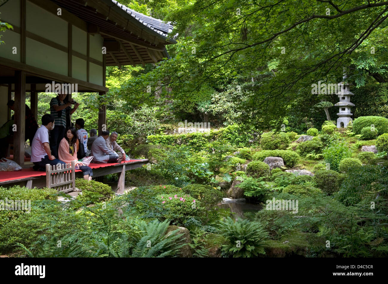 Visitors enjoying the view of a lush green Japanese landscape garden