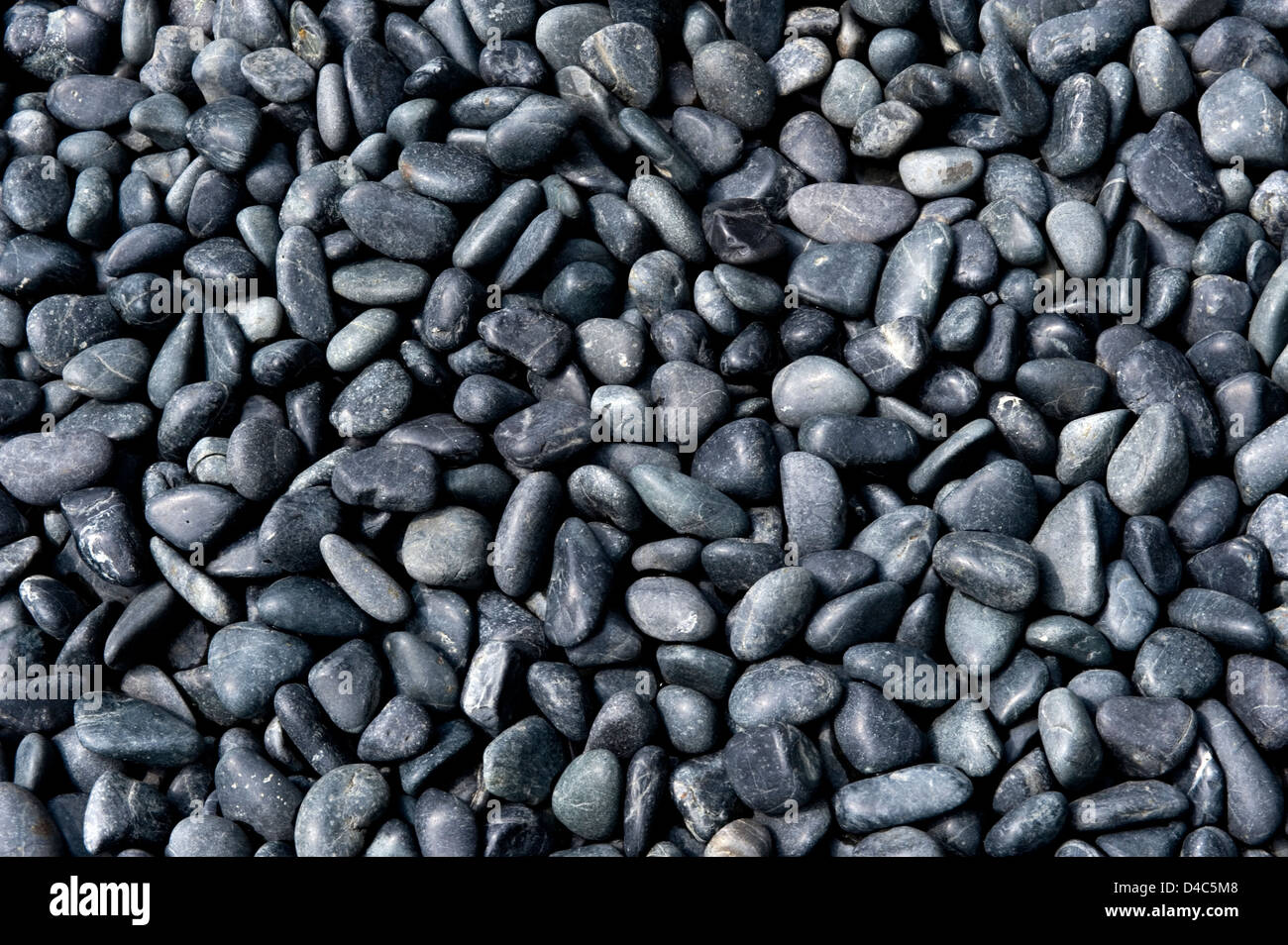 Background pattern of black and gray polished river rock in a Japanese garden at Sanzenin Temple in Ohara, Kyoto, Japan. Stock Photo