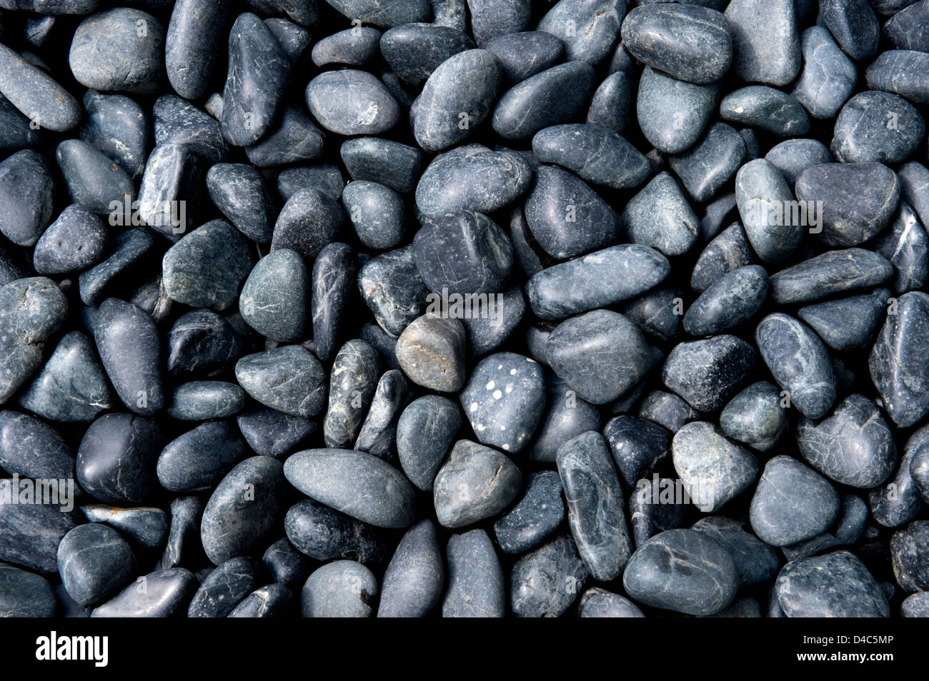 Background pattern of black and gray polished river rock in a Japanese garden at Sanzenin Temple in Ohara, Kyoto, Japan. Stock Photo