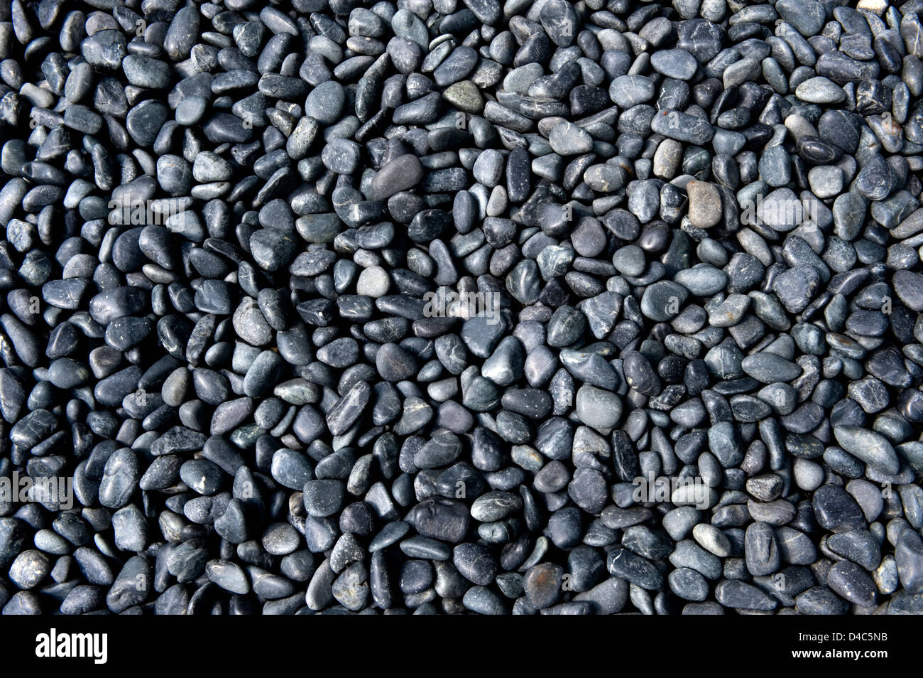 Background pattern of black and gray polished river rock in a Japanese garden at Sanzenin Temple in Ohara, Kyoto, Japan. Stock Photo