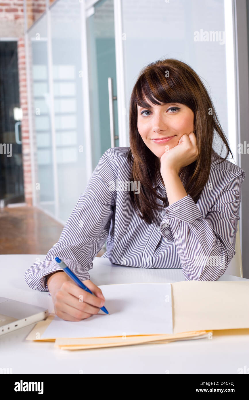 Business Woman Writing notes at desk in a modern office Stock Photo - Alamy