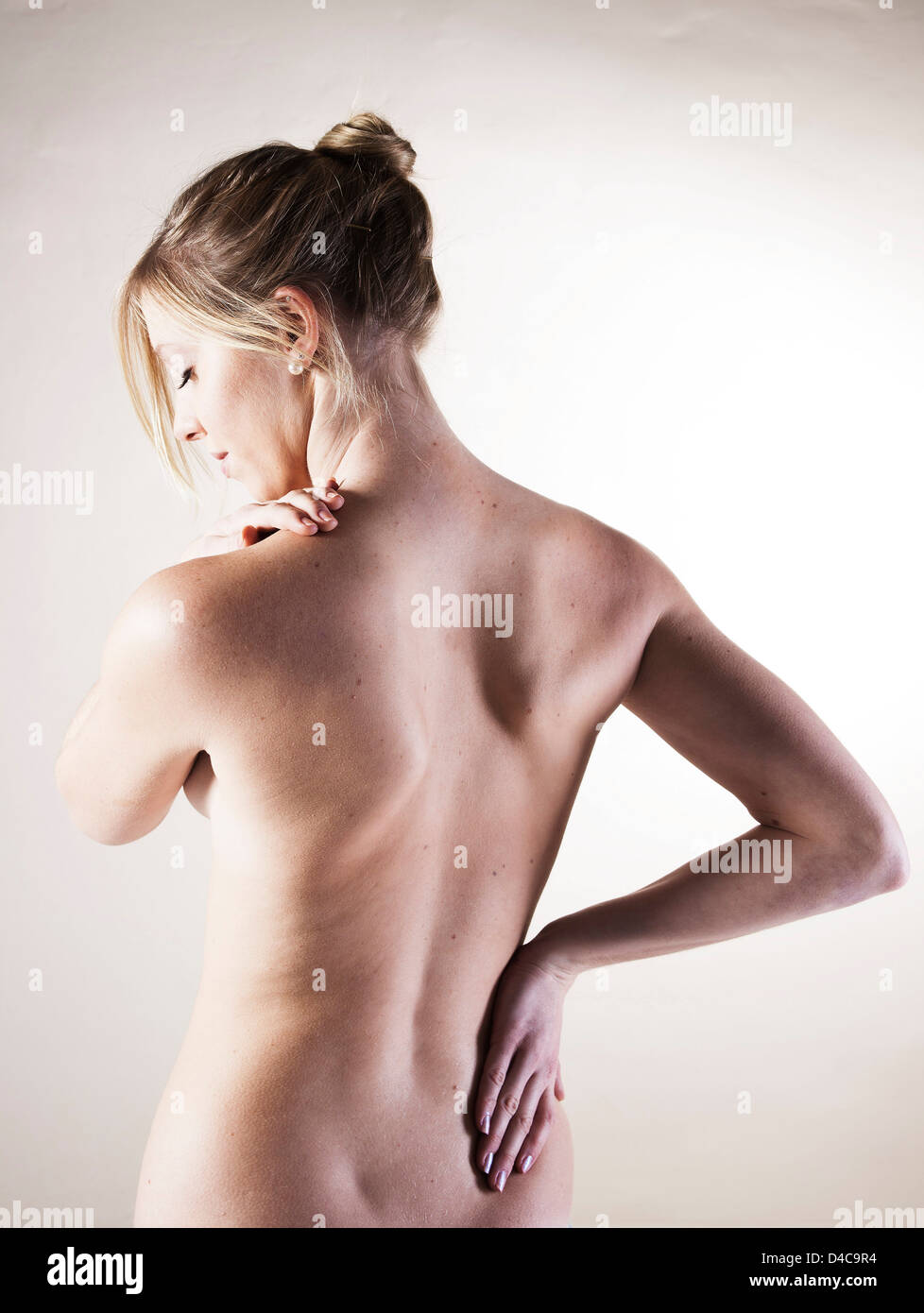 Young woman with pain in the back Stock Photo