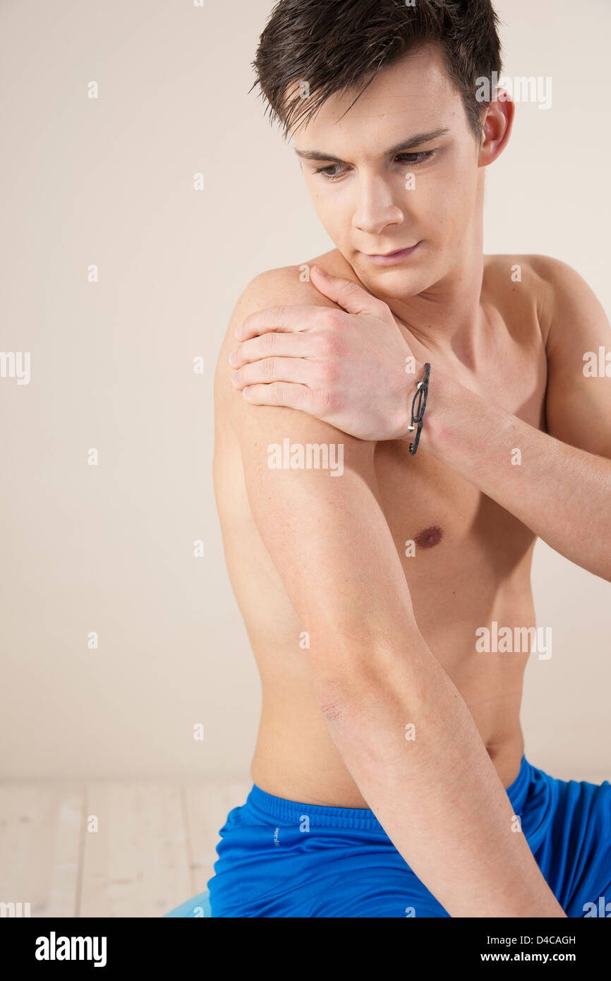 young man touching his injured arm Stock Photo