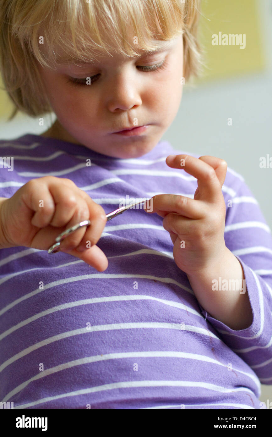 Toddler with nail scissors Stock Photo - Alamy
