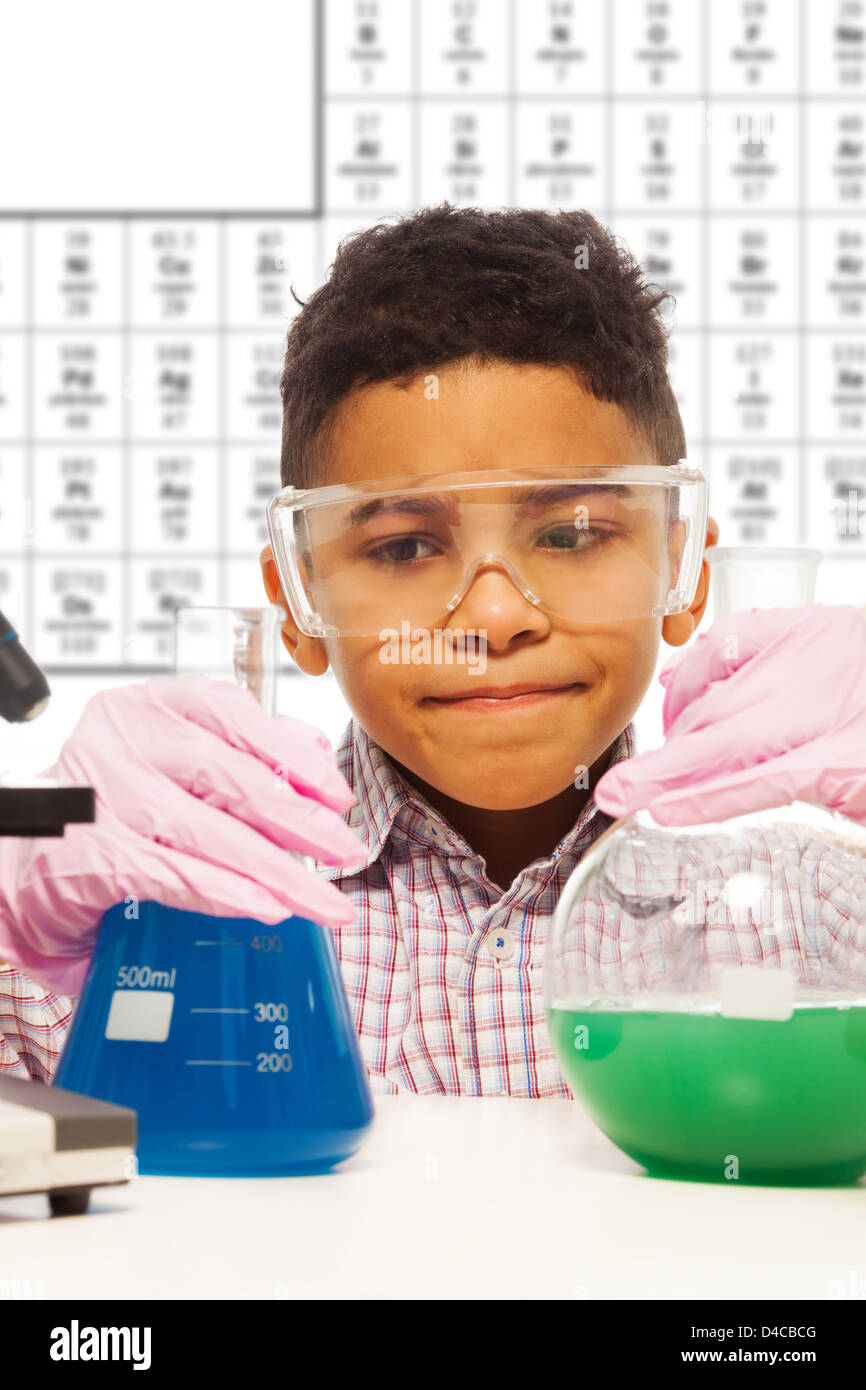 Black little boy experiments with chemistry about to mix two substances Stock Photo