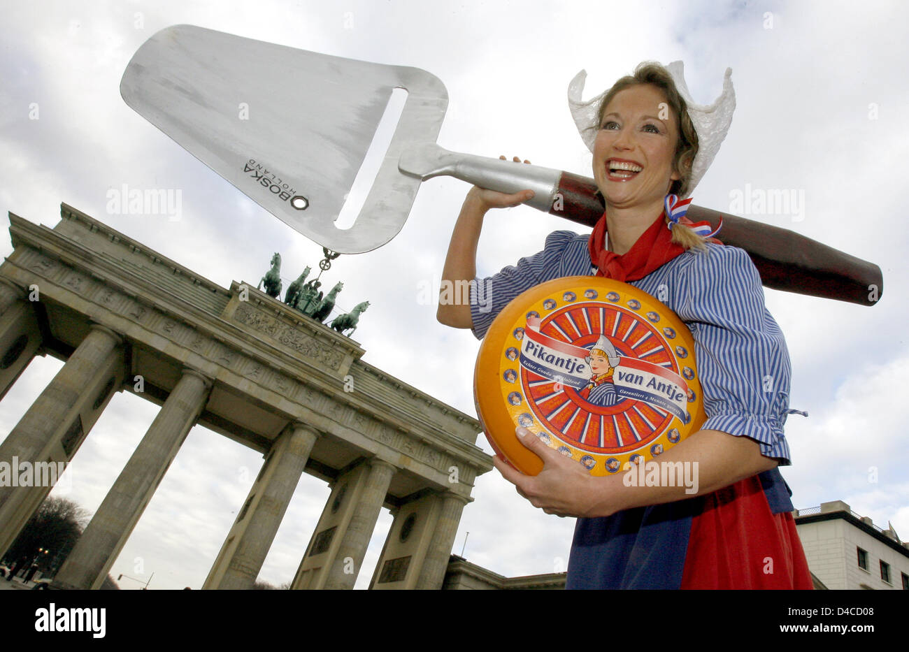 Frau Antje mascot of the Dutch dairy association carries gouda cheese  and a cheese slicer in front of the Brandenburg Gate, in Berlin, Germany, 17 January 2008. The world's largest exhibition for the food industry, agriculture and horticulture 'International Green Week' 2008 will take  place from 18 to 28 January 2008. Photo: WOLFGANG KUMM Stock Photo