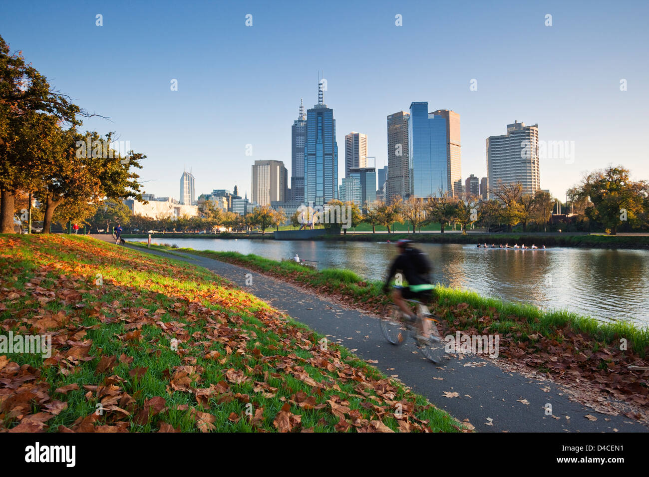 Cyclist on banks of Yarra River with city skyline in background. Melbourne, Victoria, Australia Stock Photo