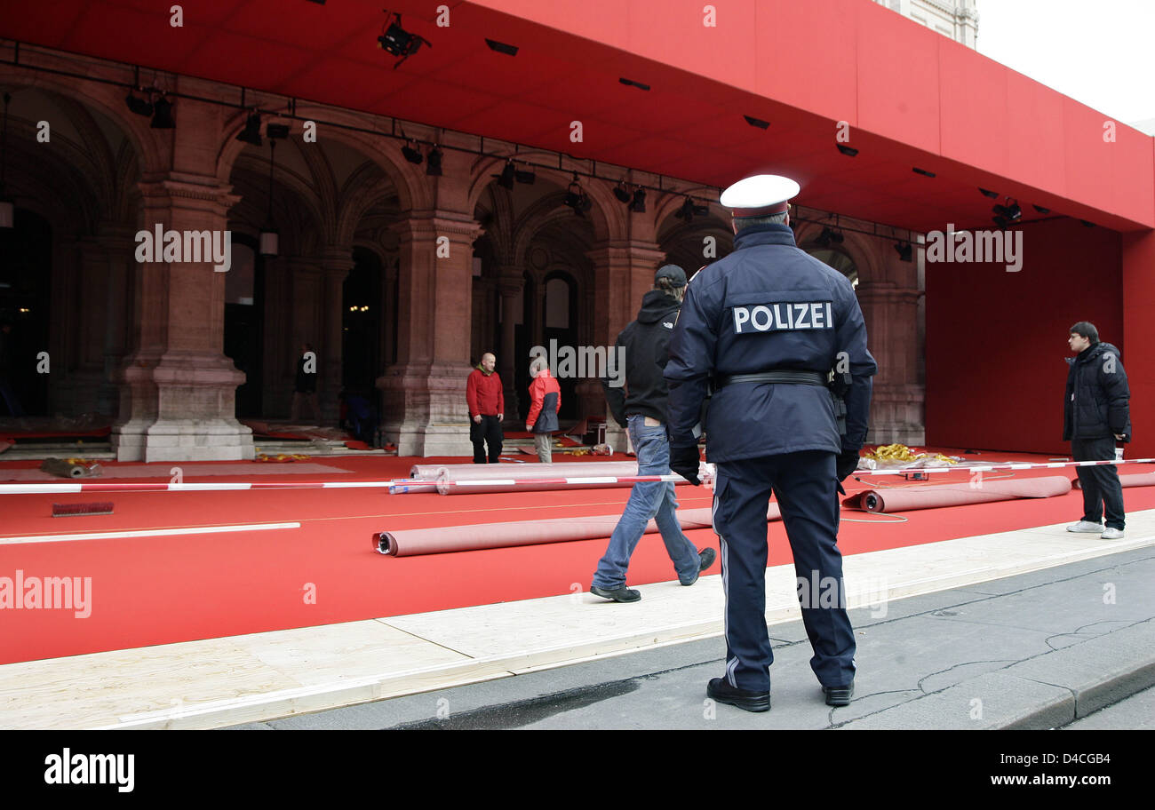 A police officer supervises the preperations of the red carpet for the Vienna Opera Ball 2008 in Vienna, Austria, 31 January 2008. A red carpet is laid out for the first time at the traditional and highly sophisticated event taking place later the evening. Photo: ARNO BURGI Stock Photo