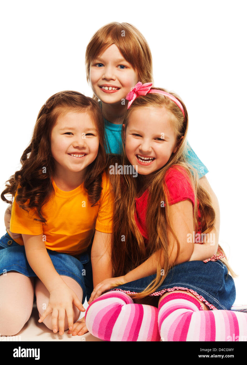 Group of three kids, two girls and boy together, Asian and Caucasian happy, laughing, hugging, sitting isolated on white Stock Photo