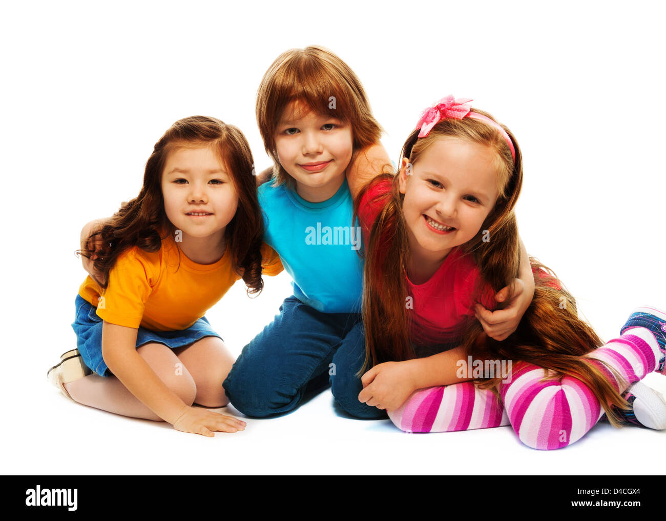 Group of three kids, two girls and boy together, Asian and Caucasian happy, hugging, sitting isolated on white Stock Photo