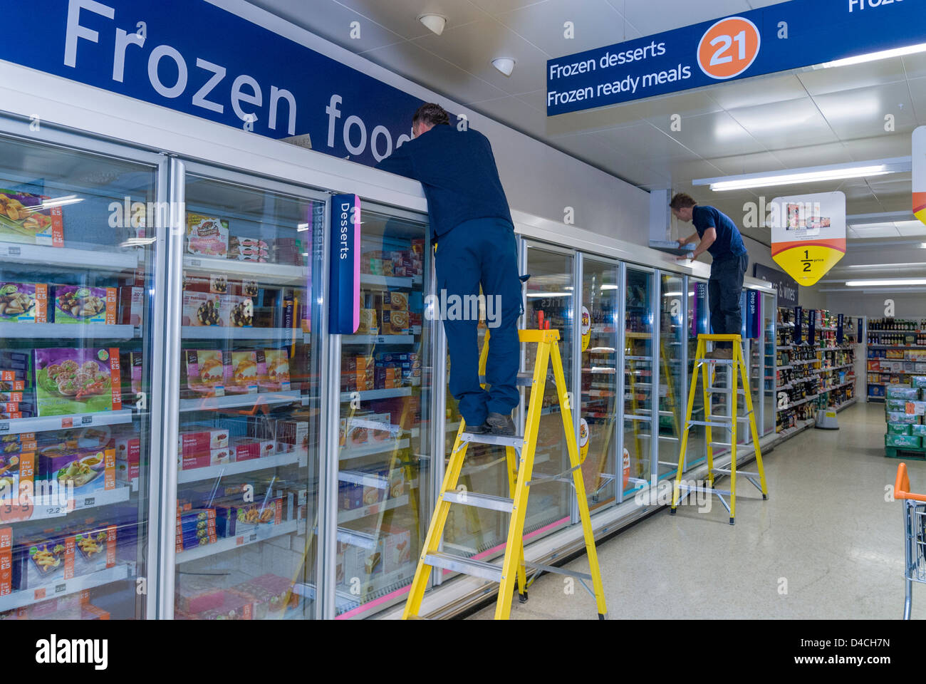 Engineers working on supermarket freezer cabinet Stock Photo