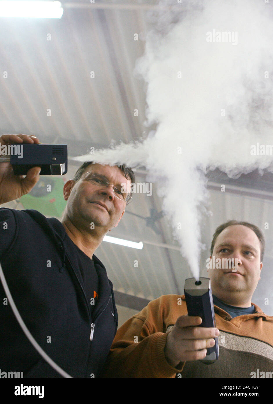 Ruediger Kleinke (L) and Joerg Poehler demonstrate their self designed micro fog machines at their company OTTEC Technology in Ronnenberg near Hanover, Germany, 5 February 2008. The Academy of Motion Picture Arts and Sciences in Hollywood awards the 'Technology Oscar' for the invention of the battery powered micro fog machine on 9th February. The device produces so-called 'tiny-fog Stock Photo
