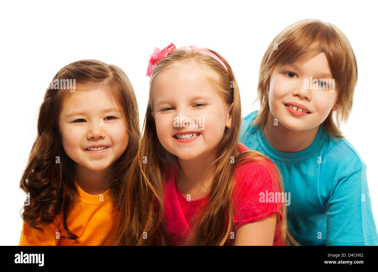 Closeup of a group of three kids, two girls and boy together, diversity looking happy, laughing, hugging, sitting on the floor isolated on white Stock Photo