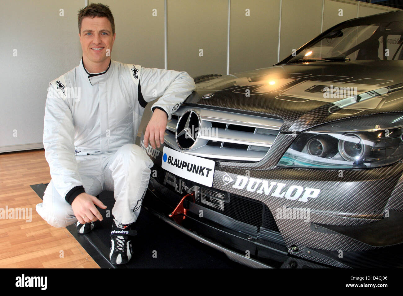 Racing driver Ralf Schumacher leans on a AMG C class Mercedes after(09)