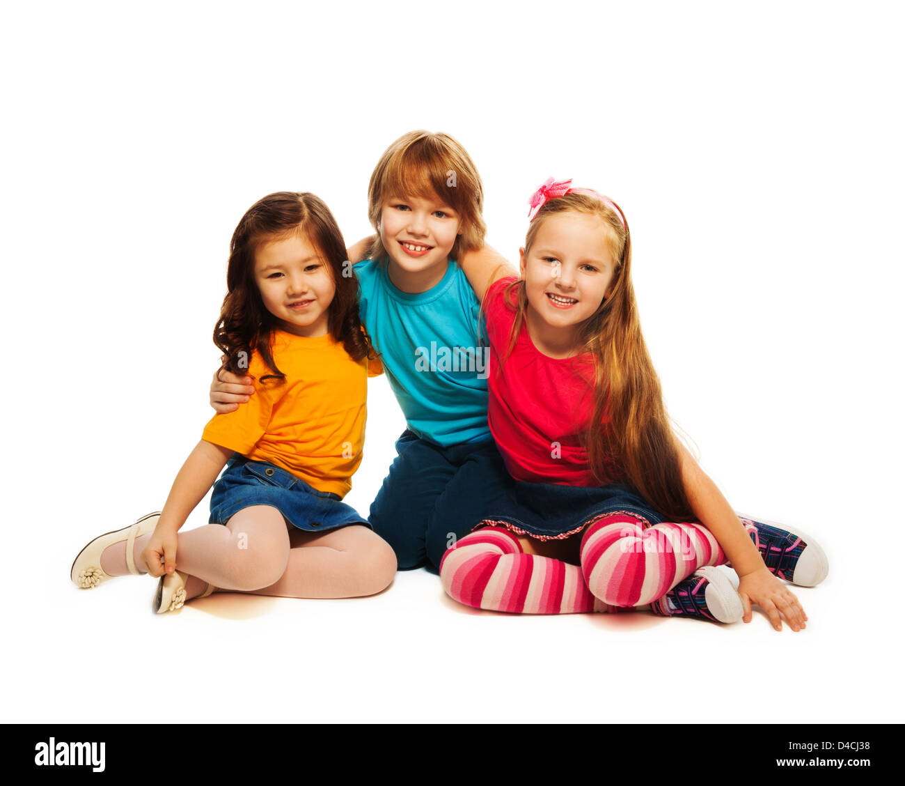 Group of three 6,7,8 yeas old kids, two girls and boy together, diversity looking happy, laughing, hugging, sitting isolated on white Stock Photo