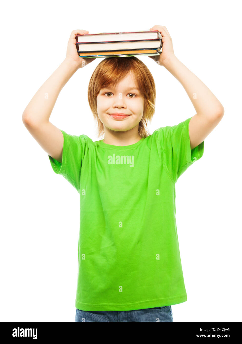 Happy Caucasian 9 years old boy in green shirt holding stack of books on top of head portrait, isolated on white Stock Photo