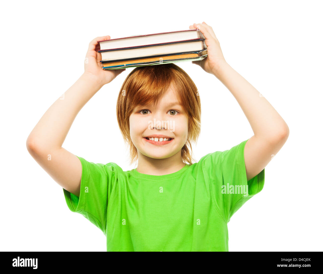 Happy Caucasian 9 years old boy in green shirt holding stack of books on top of head portrait, close-up portrait, isolated on white Stock Photo