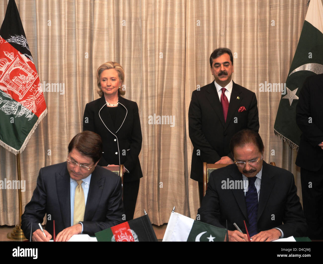 Secretary Clinton and Pakistani Prime Minister Yousaf Raza Gilani Watch Pakistani Federal Minister for Commerce Makhdoom Amin Faheem and Afghan Minister for Trade and Industries Dr. Anwarul Haq Sign a Pakistan-Afghanistan Transit Trade Agreement Stock Photo