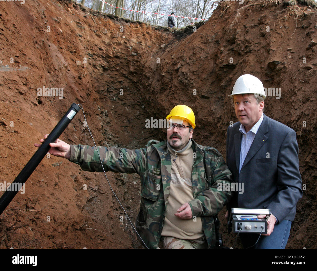 Hobby treasure hunter Christian Hanisch (L) and the local mayor Heinz-Peter Haustein search hollow spaces of a mining with a grave- and tunnel detector for hidden boxes with Nazi loot in Deutschneudorf, Germany, 08 February 2008. The contain of the boxes, parts of the legendary Amber Room or simply gold, is arguable, despite rumors have spread for years that military vehicles with  Stock Photo