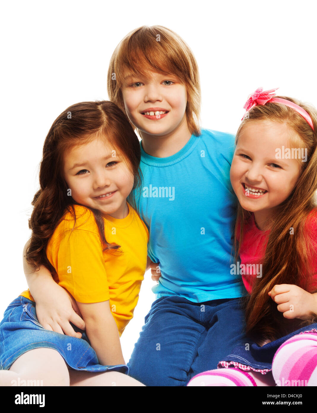 Closeup of a group of three kids, two girls and boy together, diversity looking happy, laughing, hugging, sitting isolated on white Stock Photo