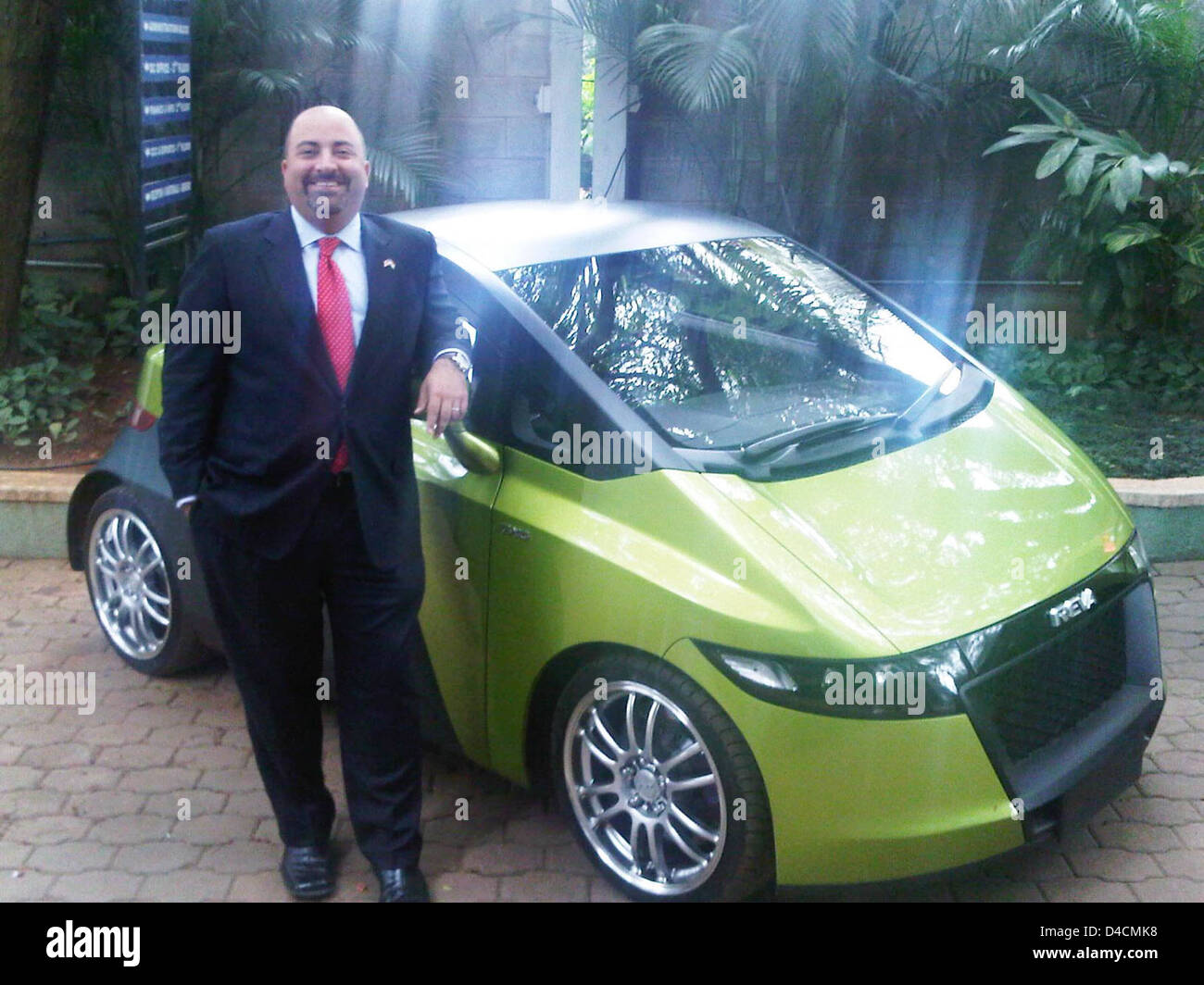 Acting Deputy Assistant Secretary Keshap Stands Beside a Mahindra Reva Electric Car Stock Photo