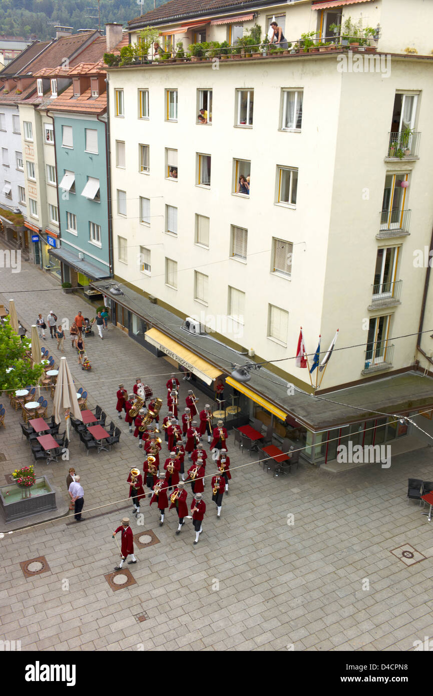 A small marching band parading through the streets of a small town in