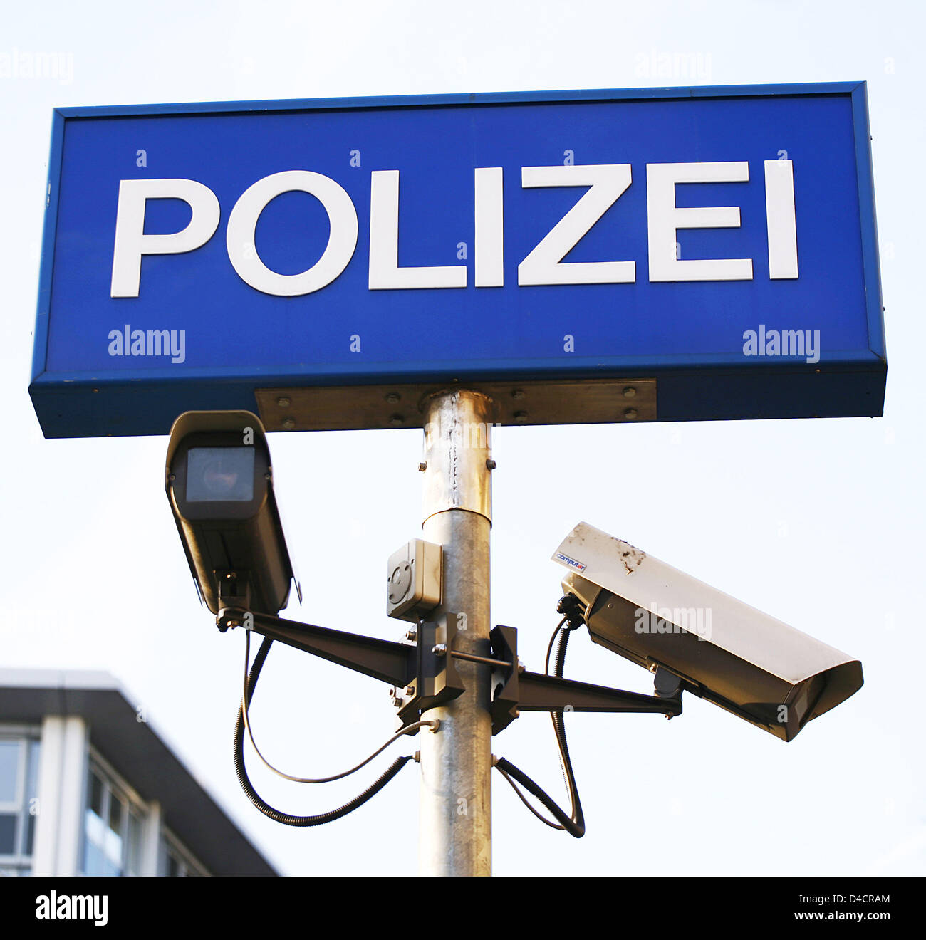 The picture shows surveillance cameras below a German police sign, in