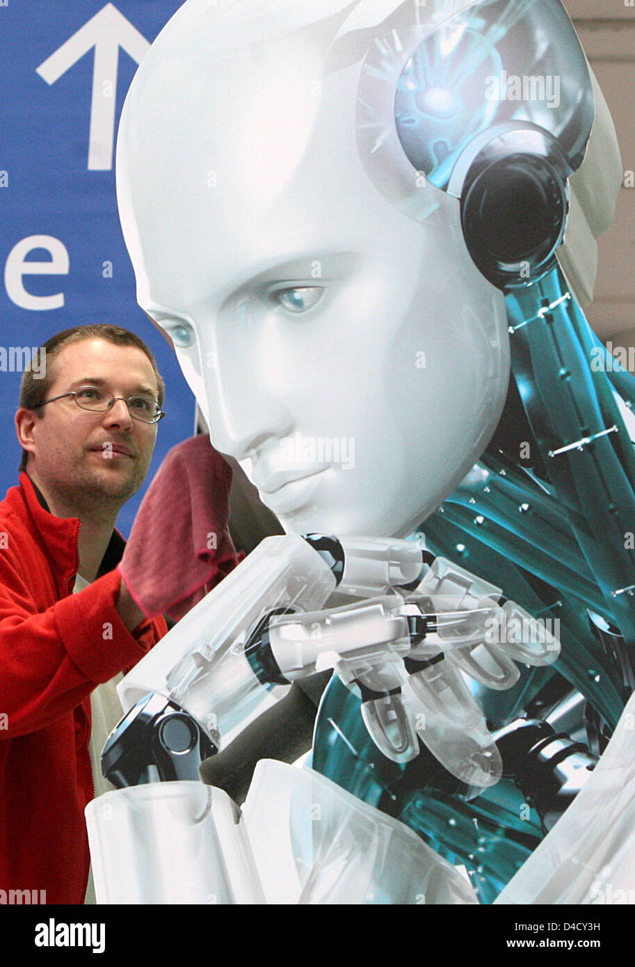 A worker polishs a robot sculpture at the trade fair premises during the preparations for the CeBIT in Hanover, Germany, 03 March 2008. From 04 through 10 March, some 5,500 exhibitors from 75 countries showcase their latest products at the world's largest trade fair on digital IT and telecommunications solutions for home and work environments. Photo: JOCHEN LUEBKE Stock Photo
