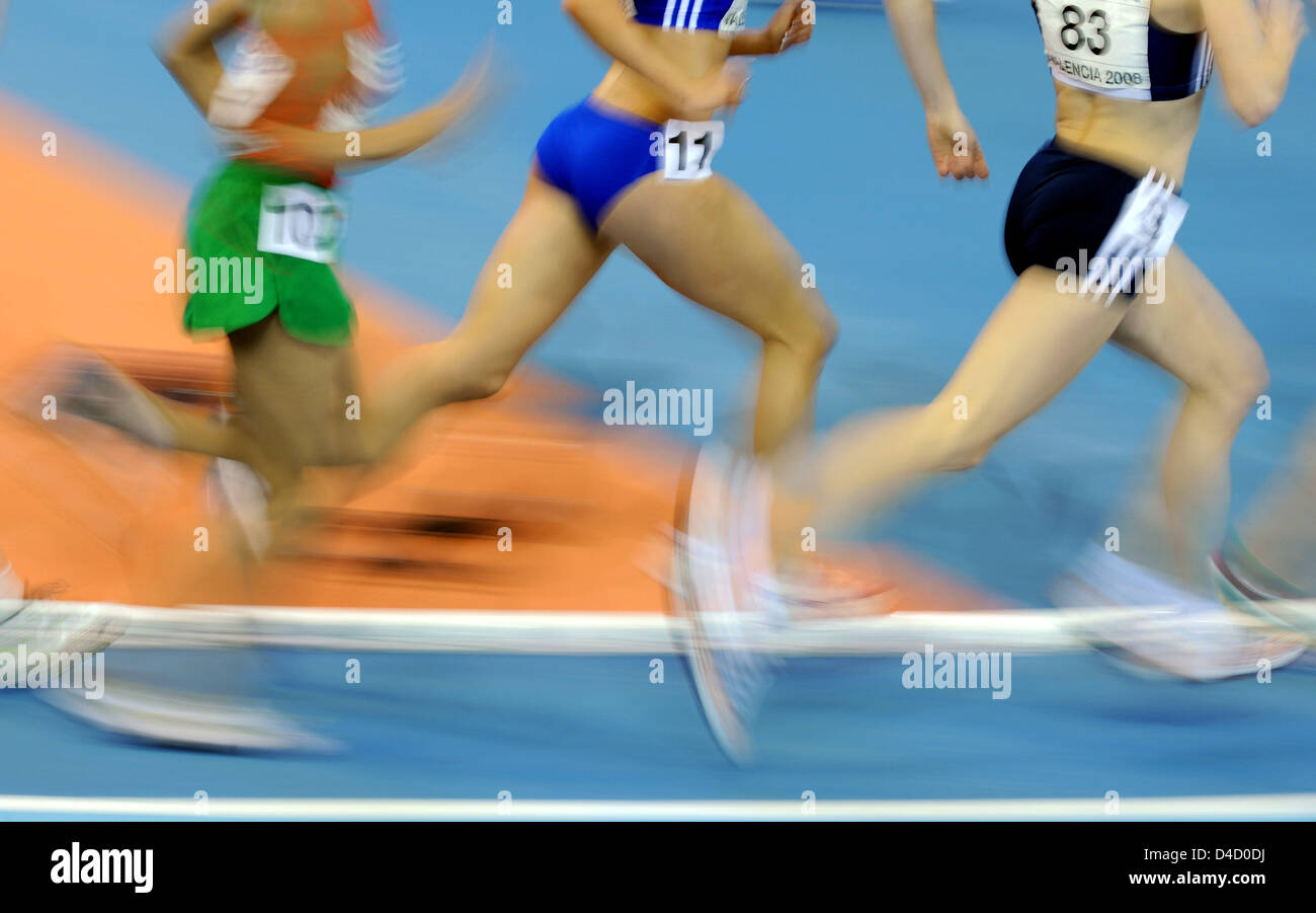 Athletes run during the women's 3,000m qualifying race at the 12th ...