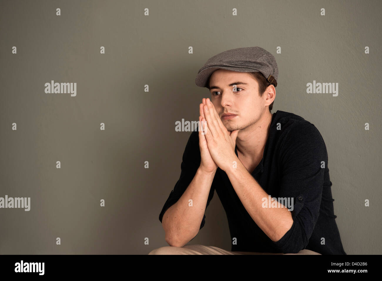 Thoughtful young man wearing cap Stock Photo